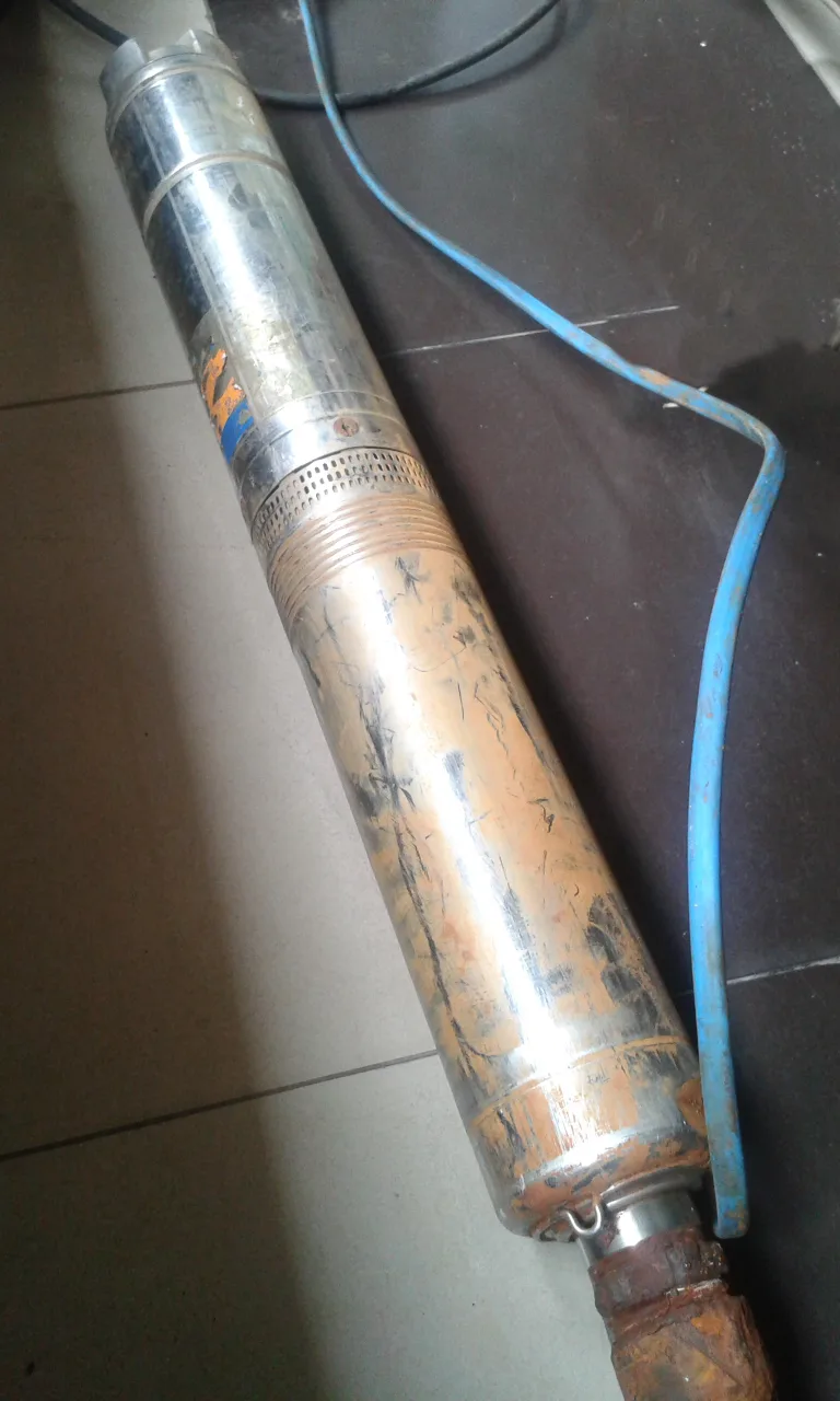 A real cylindrical submersible borehole pump with an electrical cable, shown as a reference.